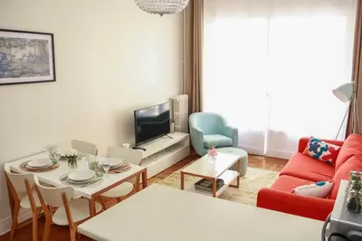 a living room with a red couch and a table at Cosy 3 pièces à 5 min de la PROM in Nice