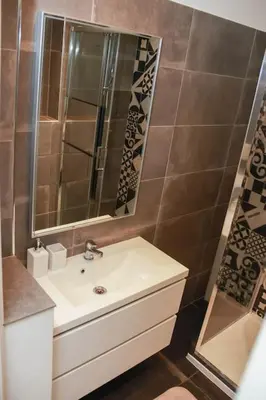 a bathroom with a sink and a mirror at Cosy 3 pièces à 5 min de la PROM in Nice