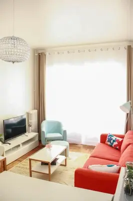 a living room with a red couch and a tv at Cosy 3 pièces à 5 min de la PROM in Nice