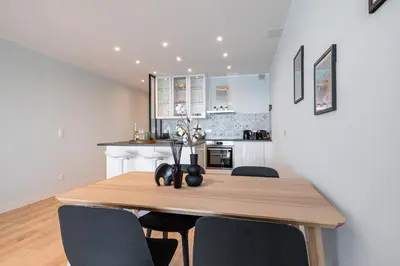 a kitchen and dining room with a wooden table and chairs at Panoramic Sea View - 1 Bdr Promenade des Anglais in Nice