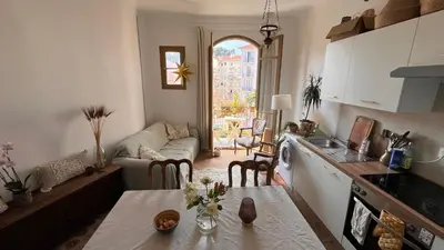 a kitchen and living room with a table and a couch at Arty room in Nice