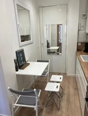 a kitchen with a white table and two chairs at Appartement Nice 2 chambre 2 lits 1 salle de bain in Nice