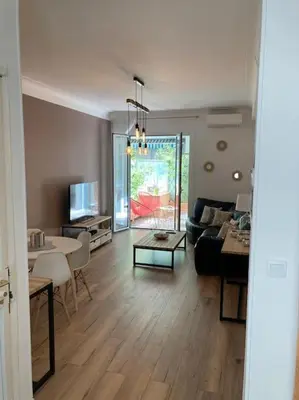 a living room with a couch and a table at Beautiful flat Nice - Palais Meyerbeer at 2min beach Negresco in Nice