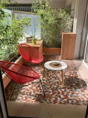 a patio with two chairs and a table on a rug at Beautiful flat Nice - Palais Meyerbeer at 2min beach Negresco in Nice
