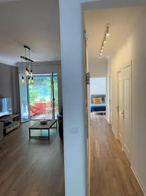 a living room with a wooden floor and a room with a table at Beautiful flat Nice - Palais Meyerbeer at 2min beach Negresco in Nice