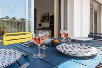 a blue table with plates and wine glasses on it at Le Mimosa - Calm - Spacious - 200m from the sea - Parking in Cagnes-sur-Mer