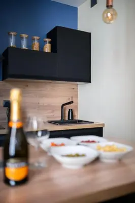 a counter with bowls of food and a bottle of beer at Raffinement en pleine ville in Nice