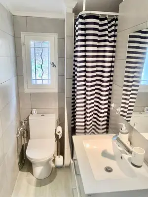 a bathroom with a toilet and a sink and a window at THE GREEN OASIS breathtaking sea views, swimming pool, privacy in Villa Liliana in Tourrette-Levens