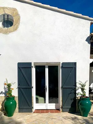 a white building with two doors and two vases at THE GREEN OASIS breathtaking sea views, swimming pool, privacy in Villa Liliana in Tourrette-Levens