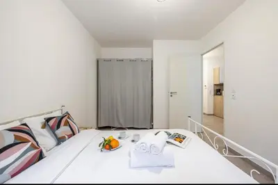 a white bedroom with a bed with a mirror at Appartement nice in Nice