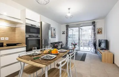 a kitchen and living room with a table with fruits on it at Appartement nice in Nice