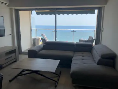 a living room with a couch and a table and a large window at Eros in Nice
