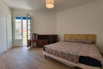 a bedroom with a bed and a sliding glass door at Apartment 3 pieces par la mer avec climatisation in Nice