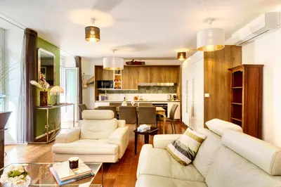 a living room with white furniture and a kitchen at New vieille ville cimiez Centre Nice in Nice