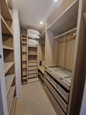 a walk in closet with wooden cabinets and shelves at Charmant 2 pièces Centre Ville in Nice