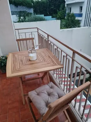 a wooden table and two chairs on a balcony at Charmant 2 pièces Centre Ville in Nice
