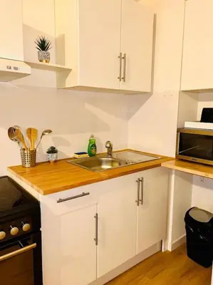 a white kitchen with a sink and a microwave at City & Serenity - Studio Proche Gare in Nice