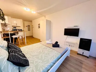 a bedroom with a large bed and a flat screen tv at City & Serenity - Studio Proche Gare in Nice