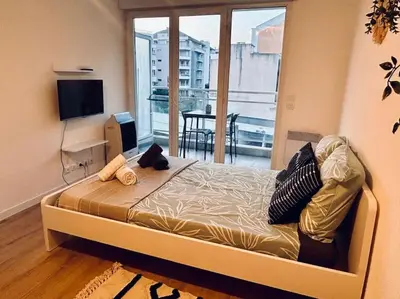 a bedroom with a bed and a large window at City & Serenity - Studio Proche Gare in Nice