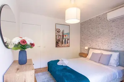 a bedroom with a bed and a vase of flowers at 86m- Spacious 3 room apartment with large terrace in Villefranche-sur-Mer