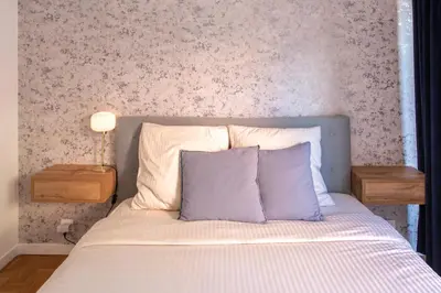 a bedroom with a bed with two night stands and two tables at 86m- Spacious 3 room apartment with large terrace in Villefranche-sur-Mer