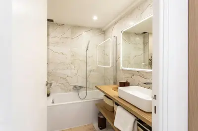 a bathroom with a sink and a tub and a mirror at 86m- Spacious 3 room apartment with large terrace in Villefranche-sur-Mer