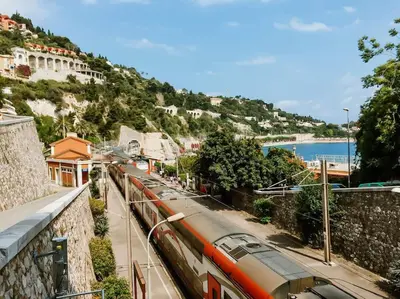 a train is on a track next to a street at 86m- Spacious 3 room apartment with large terrace in Villefranche-sur-Mer
