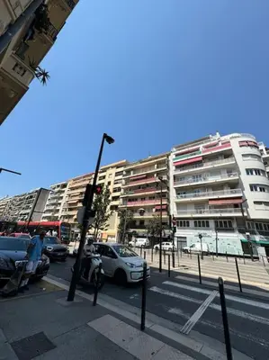 a street with cars parked in front of a building at Magnifique 2 pièces à 2 pas de la mer in Nice
