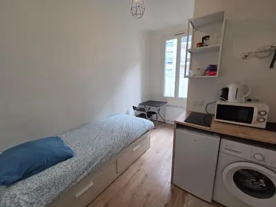 a bedroom with a bed with a blue pillow on it at Studio Niçois Proche Mer in Nice