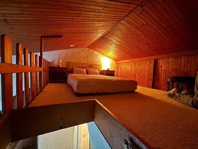 a bedroom with a bed in a wooden room at Studio dans Villa Don Quijote Nice in Nice