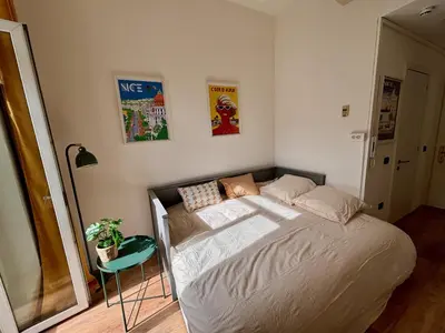 a small bedroom with a bed and a table at Studio gare Nice Clim in Nice
