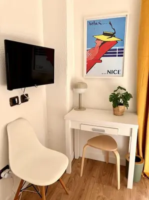 a white desk with a chair and a tv at Studio gare Nice Clim in Nice