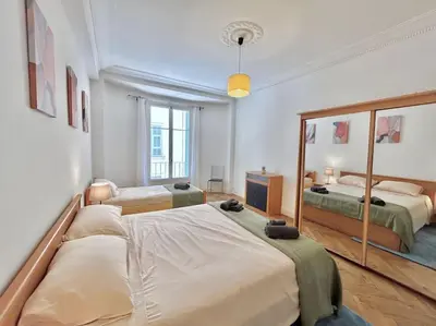 a bedroom with two beds and a large mirror at Charmant 3P en centre ville, spacieux et calme in Nice