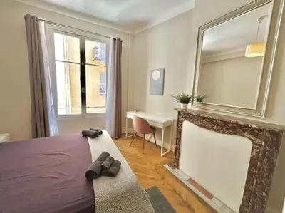 a bedroom with a bed and a mirror and a desk at Charmant 3P en centre ville, spacieux et calme in Nice