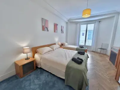 a bedroom with a large bed and a table at Charmant 3P en centre ville, spacieux et calme in Nice
