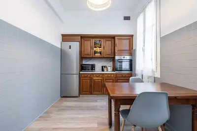 a kitchen with a wooden table and a refrigerator at Large Central 2 Bdr & Garage in Nice