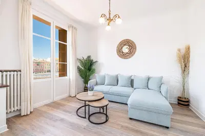 a living room with a blue couch and a table at Large Central 2 Bdr & Garage in Nice