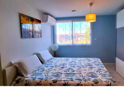 a bedroom with a bed with a floral bedspread at Maison L'Aloé in Nice