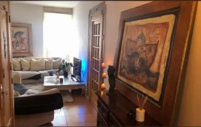 a living room with a couch and a painting on the wall at Room near Nice Port in a shared apartment in Nice