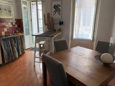a dining room with a wooden table and chairs at Room for NUDISTS near Nice port in a shared apartment in Nice