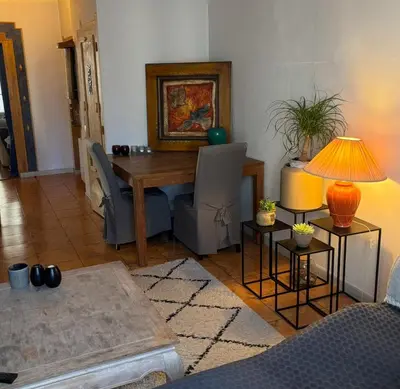 a living room with a wooden table and chairs at Room for NUDISTS near Nice port in a shared apartment in Nice