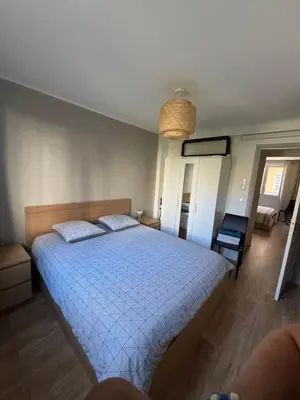 a bedroom with a large bed with a blue comforter at Appartement confortable et cosy sur le port de Nice in Nice