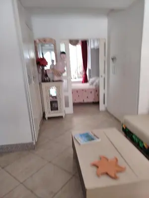a living room with a table and a room with a person in the mirror at Un jardin en Ville in Nice
