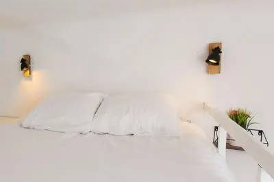 a white bed in a white room with two lights at - - Superbe Studio avec Balcon - Nice Centre - - in Nice