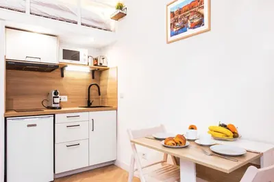 a small kitchen with a wooden table and a dining room at - - Superbe Studio avec Balcon - Nice Centre - - in Nice