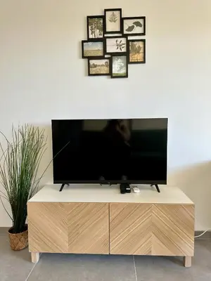a flat screen tv sitting on top of a wooden entertainment center at Side Ocean View Studio, 24H Check-In and Out, Air Conditioner, Close to Airport in Cagnes-sur-Mer