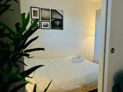 a bedroom with a white bed and a plant at Side Ocean View Studio, 24H Check-In and Out, Air Conditioner, Close to Airport in Cagnes-sur-Mer
