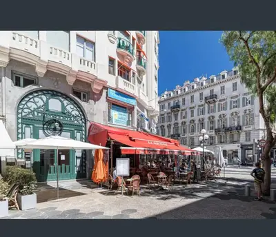 a street with tables and chairs and umbrellas and buildings at Studio au coeur du centre ville de Nice in Nice