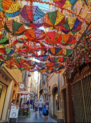 a group of people walking down a street with colorful flags at Studio au coeur du centre ville de Nice in Nice