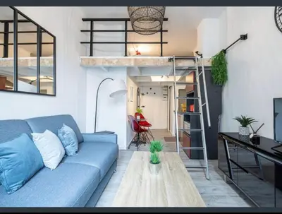 a living room with a blue couch and a loft bed at Studio au coeur du centre ville de Nice in Nice